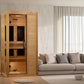 Golden Designs Veneto infrared sauna with light wood construction and dark glass doors, displayed in modern living room setti