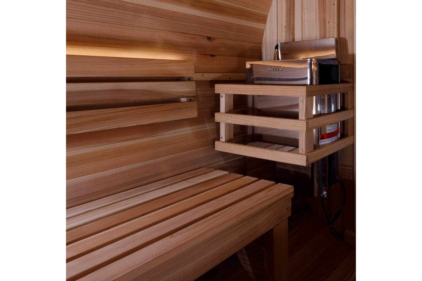 Cedar sauna interior with tiered wooden benches, wall-mounted shelving with Harvia heater, and wooden ceiling beams