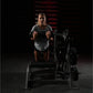 Woman wearing gray t-shirt using Hammer Strength assisted leg press machine in gym setting