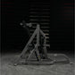 Black Hammer Strength assisted Nordic ham machine with metal frame and foot platform on gray concrete floor