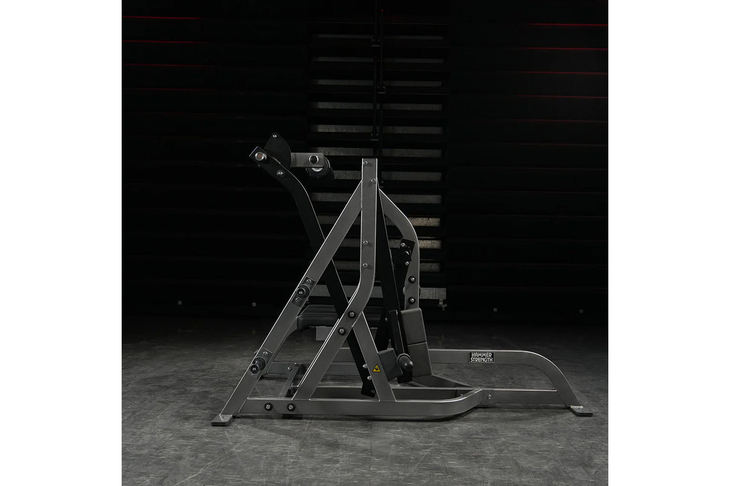 Black Hammer Strength assisted Nordic ham machine with metal frame and foot platform on gray concrete floor