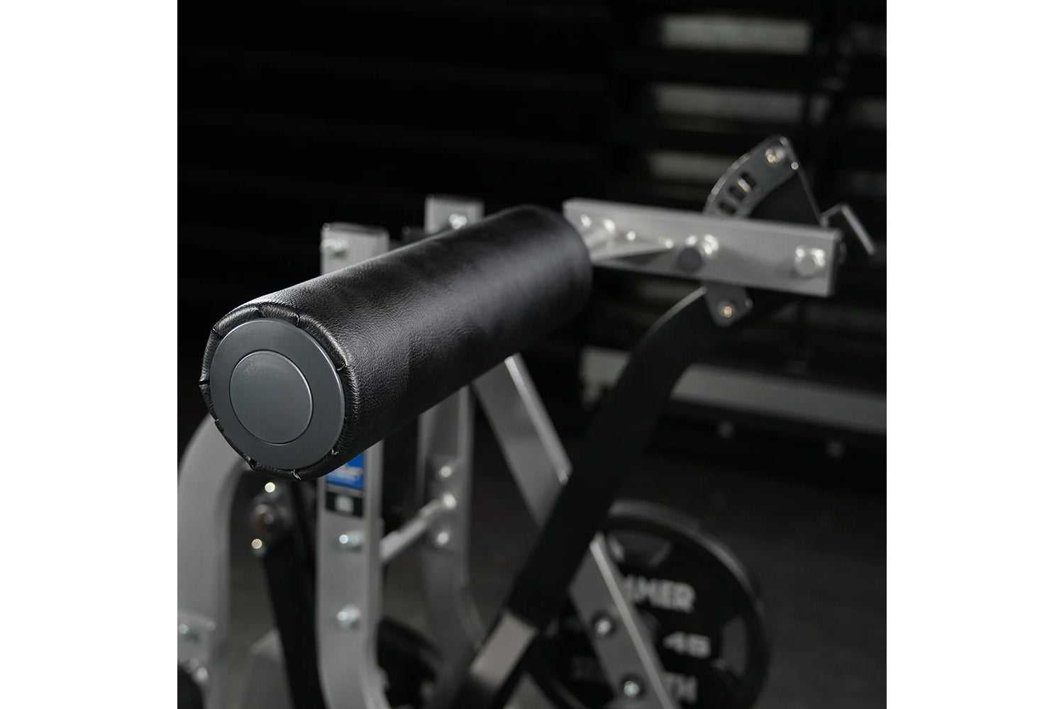 Black padded handlebar with circular button on exercise machine, close-up detail view