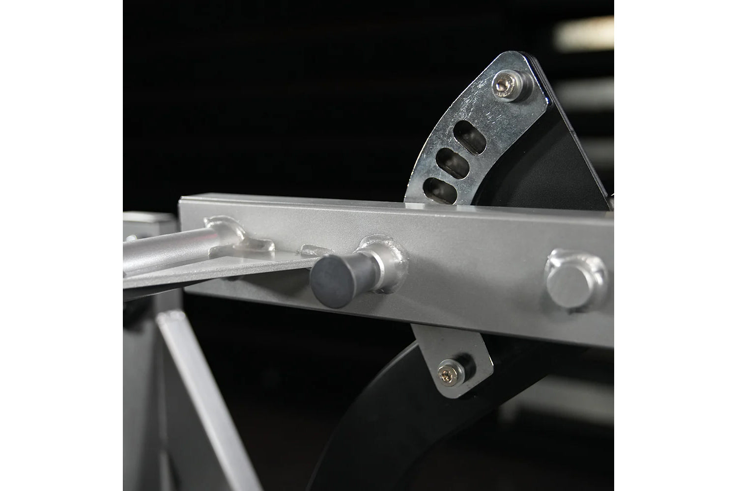 Hammer Strength Assisted Nordic Ham lever arm detail with metal bracket and adjustment pegs on black background
