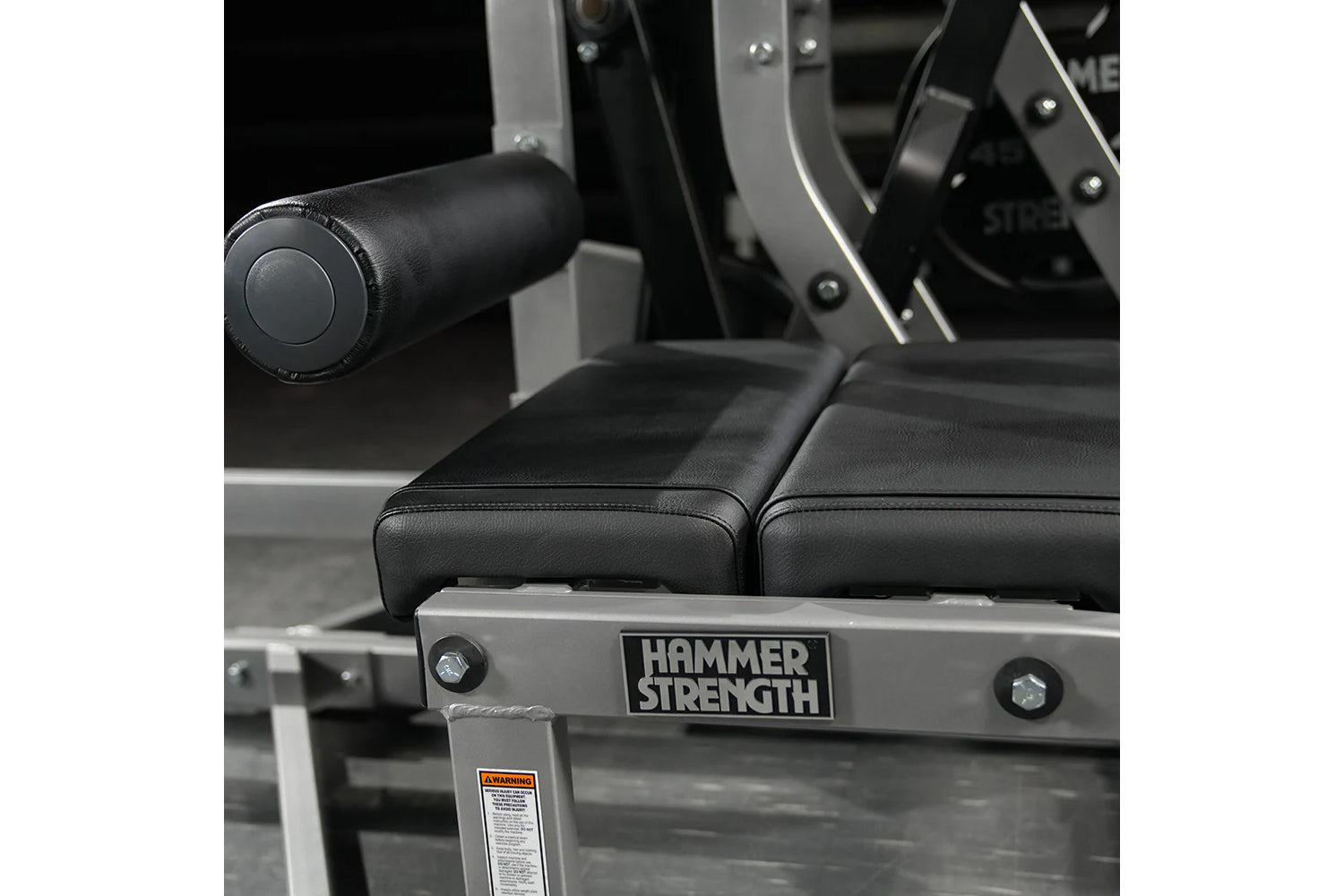 Hammer Strength assisted Nordic ham machine with black padded seat and handles, silver metal frame detail visible