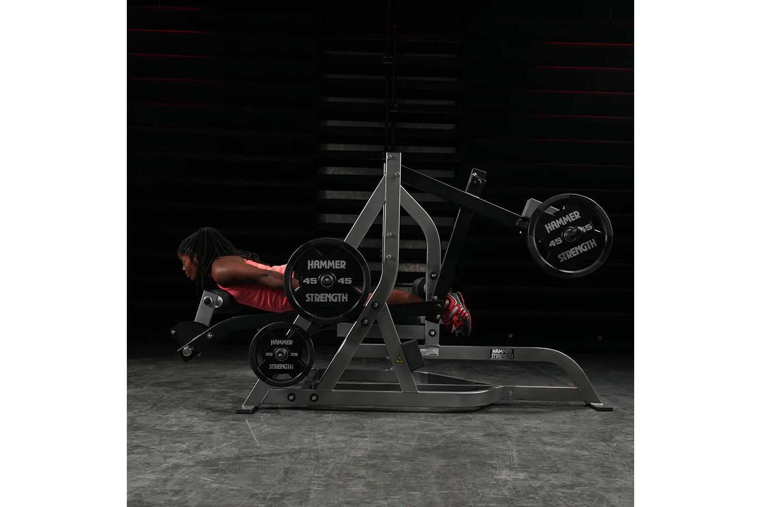 Hammer Strength assisted Nordic ham machine with black frame and weight plates, model shown in use with person wearing red sh