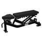 Hammer Strength black weight bench with adjustable backrest and leg extension attachment on white background