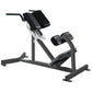 Black and gray Hammer Strength back extension machine with adjustable back pad, footplate, and handlebar on white background