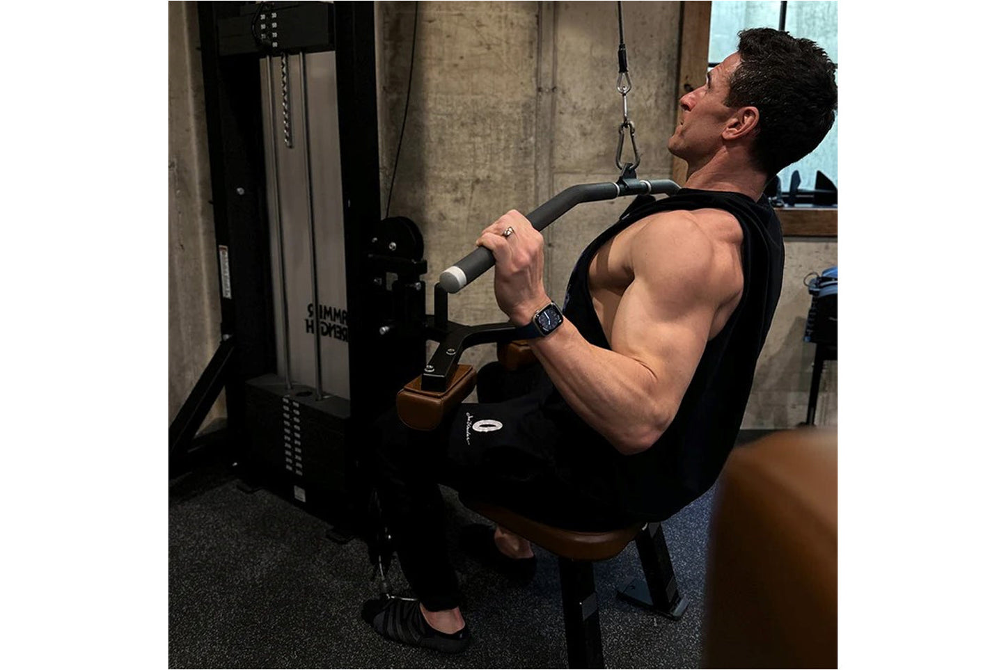 Man using black Hammer Strength dual pulldown/row machine in gym setting