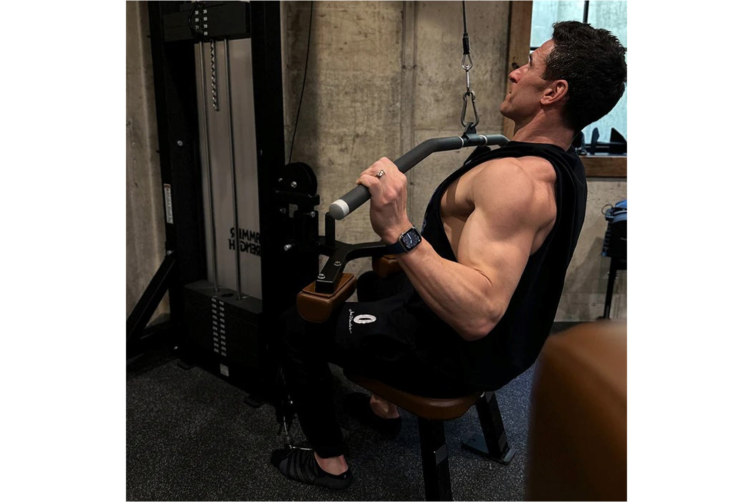 Man using black Hammer Strength dual pulldown/row machine in gym setting