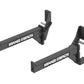 Pair of black Hammer Strength weight rack bar catchers with adjustable arms and metal pins, flat lay on white background