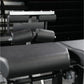 Black padded leg extension machine with cylindrical foam rollers and metal frame, gym equipment detail shot