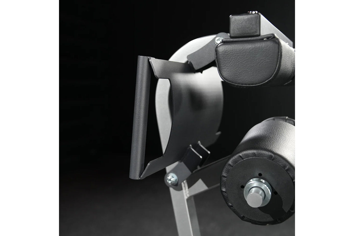 Black and gray exercise machine with padded leather seat, leg extension attachment, and control dial on black background
