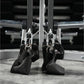 Pair of black foam handles with silver carabiners attached to gym machine equipment with metal frame and rollers