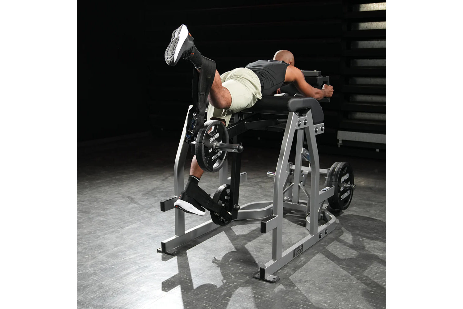 Man using silver and black Hammer Strength Glute-Ham Reverse Hyper Combo machine in gym setting, demonstrating leg extension 