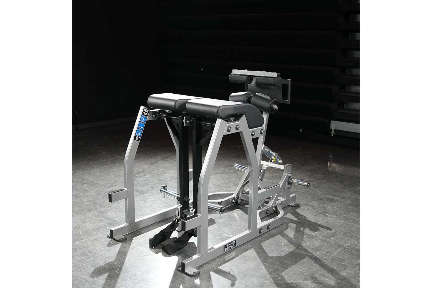 Hammer Strength silver and black glute-ham reverse hyper combo bench machine with padded seat and leg attachment on gray floo