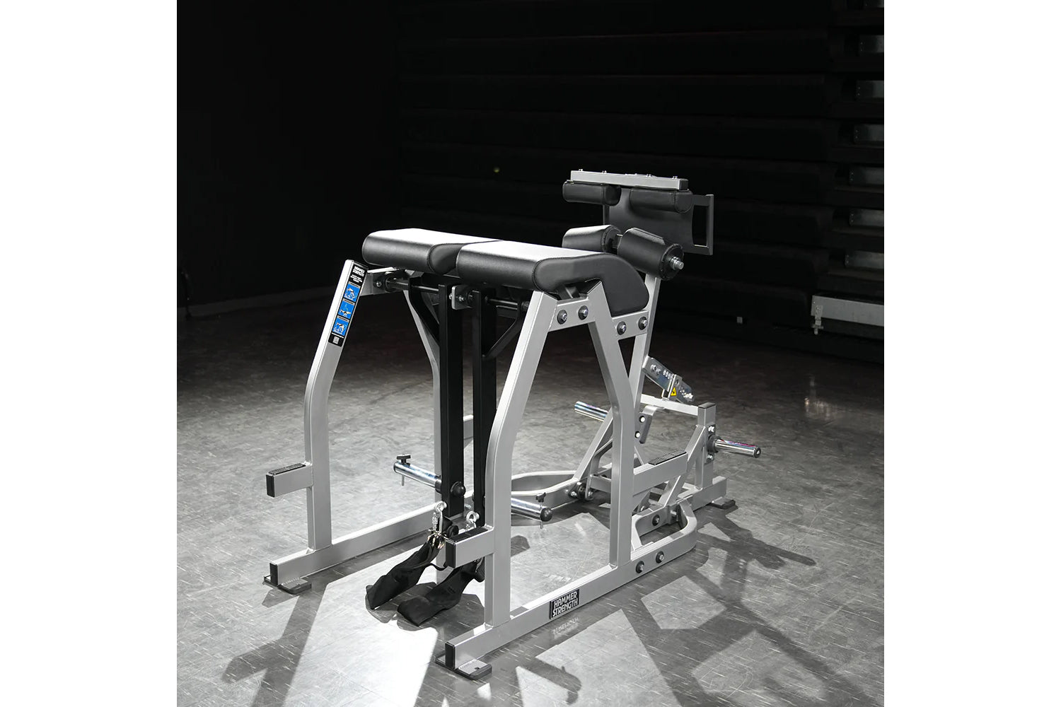 Hammer Strength silver and black glute-ham reverse hyper combo bench machine with padded seat and leg attachment on gray floo