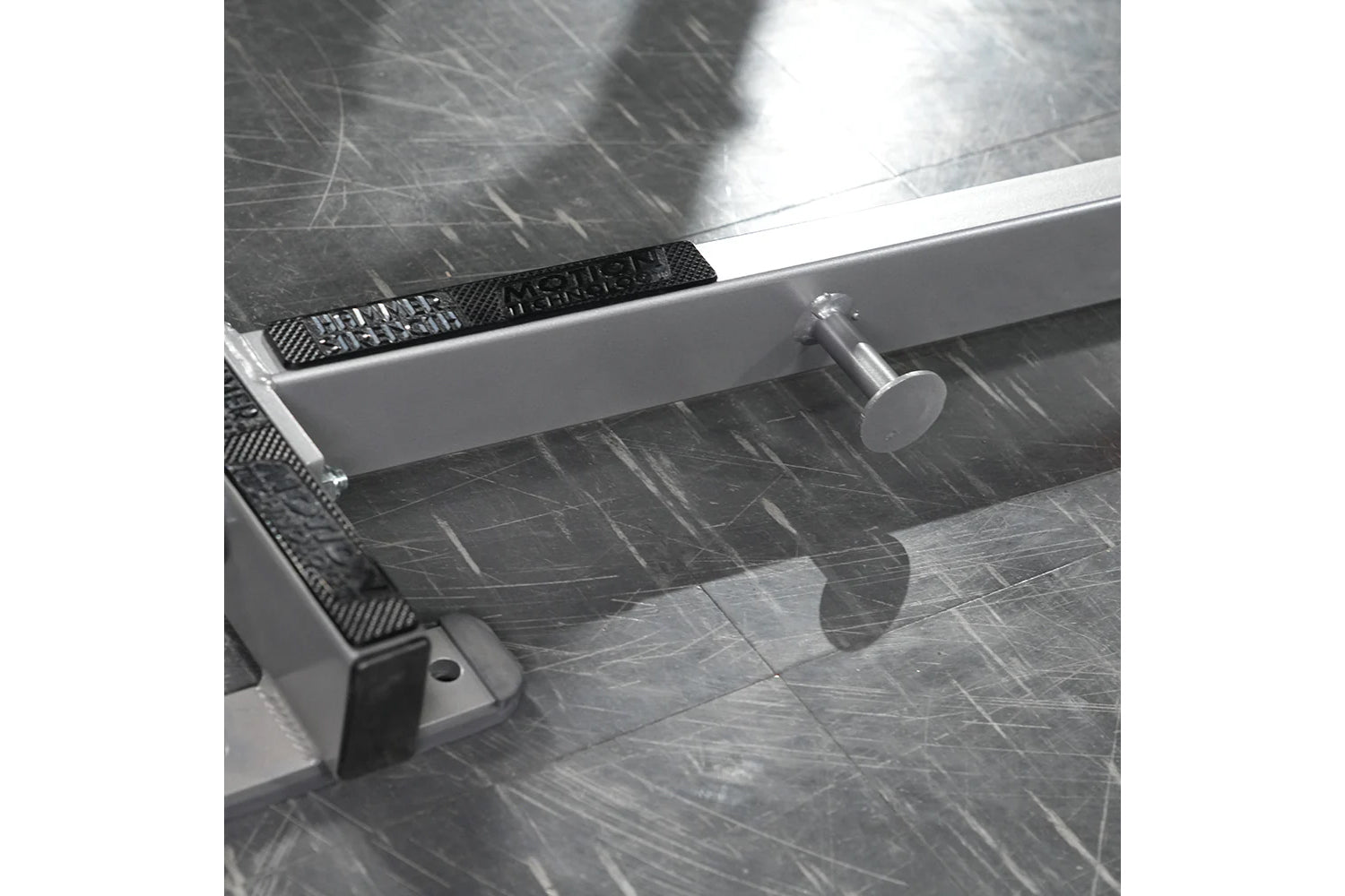 White and black Hammer Strength Ground Base Jammer with metal frame and foot platform on dark textured floor