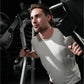 Man wearing light gray t-shirt using Hammer Strength black and gray jammer machine with handles during workout