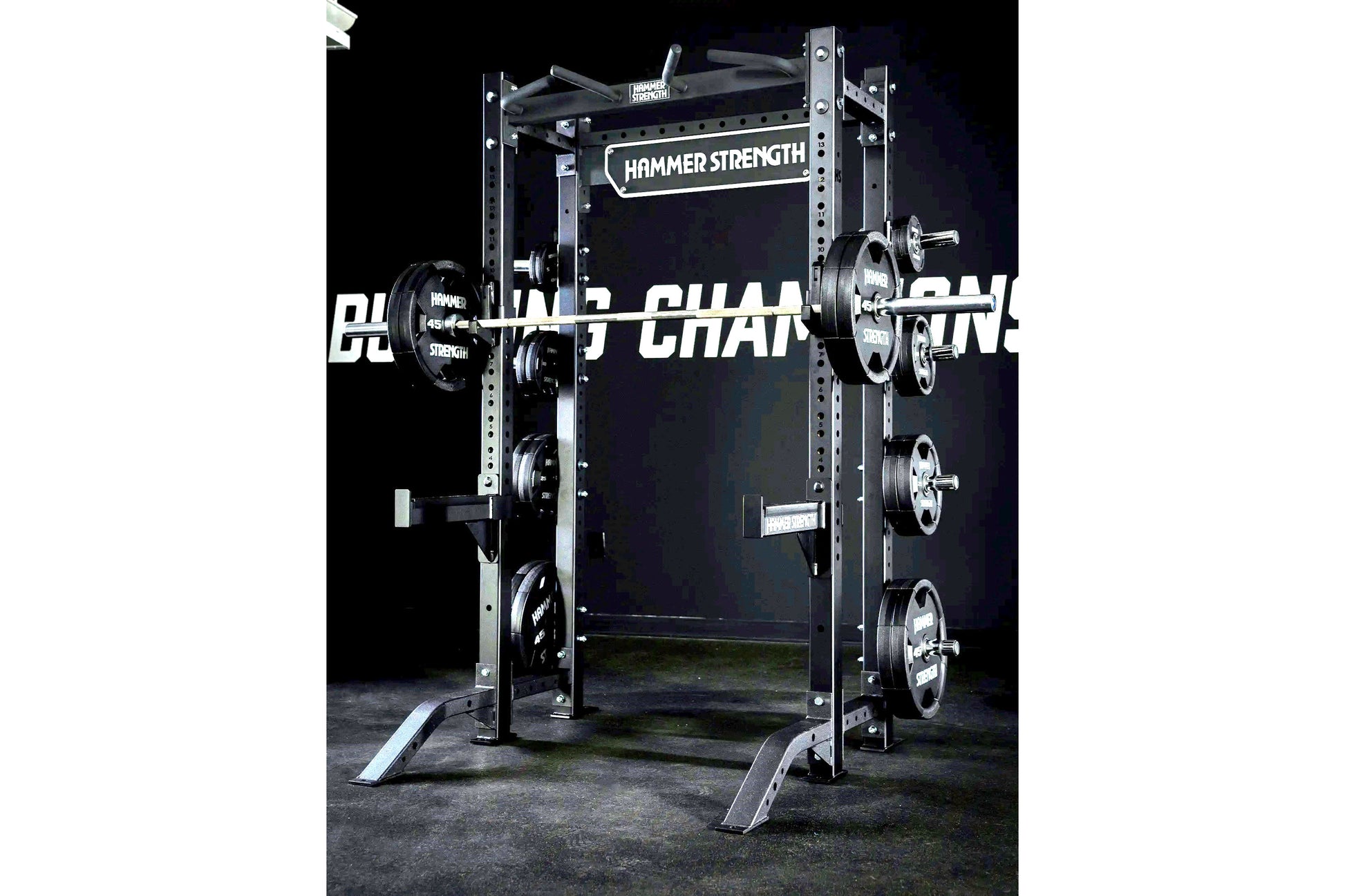 Hammer Strength HD Athletic NX Half Rack with black steel frame, loaded weight plates on barbell, on concrete floor