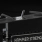 Hammer Strength HD Athletic NX Half Rack with black padded bar and gray metal uprights on black background