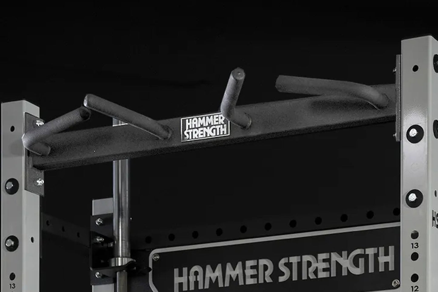 Hammer Strength HD Athletic NX Half Rack with black padded bar and gray metal uprights on black background