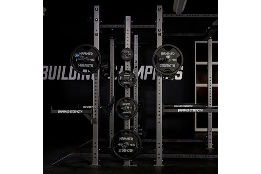 Hammer Strength HD Athletic NX Power Half Combo Rack with black weight plates loaded on vertical bar, industrial steel frame 