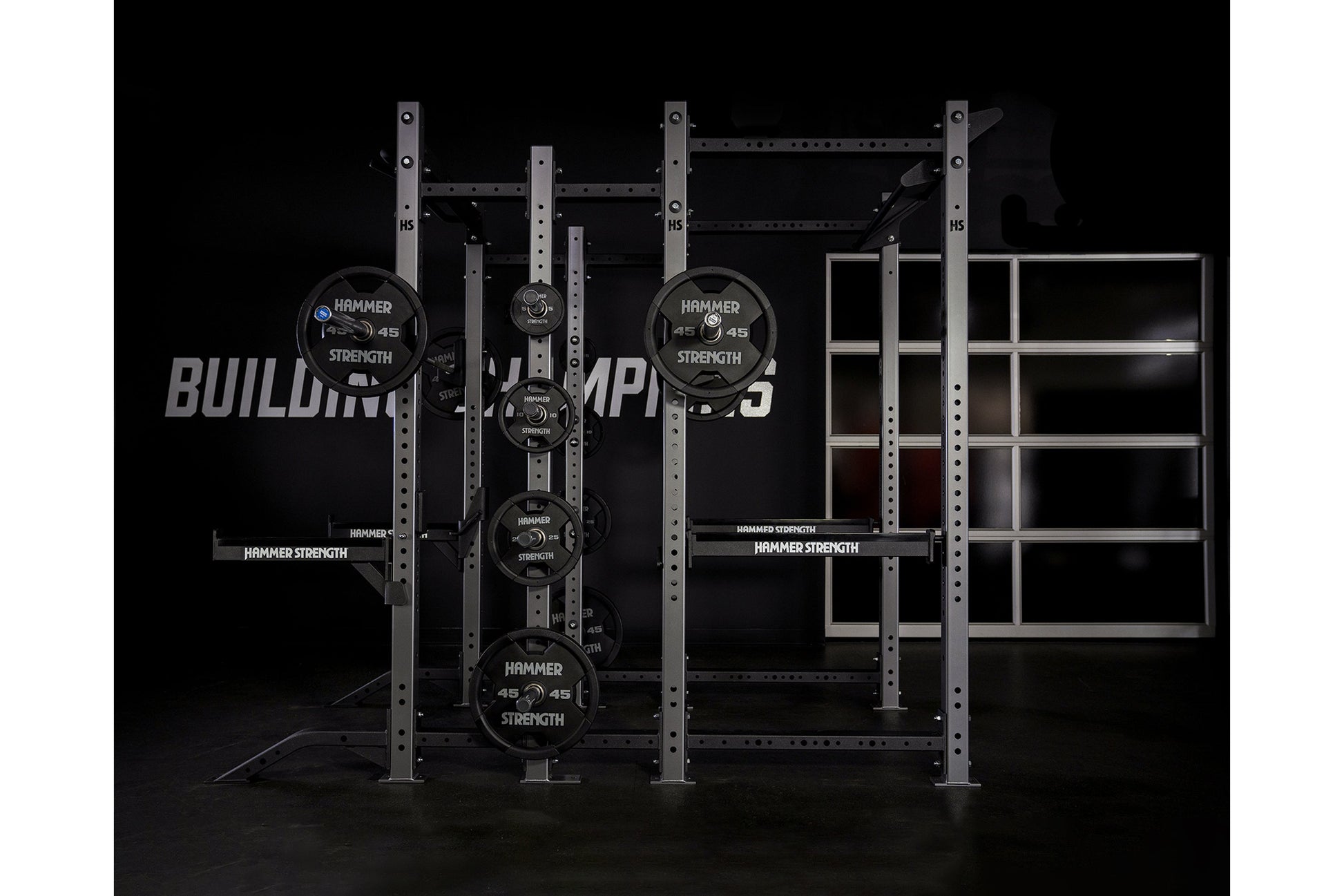Hammer Strength HD Athletic NX Power Half Combo Rack with black weight plates and steel frame on black background