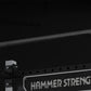 Hammer Strength HD Athletic NX Squat Stand with black steel frame, gray uprights, and safety catches on black background