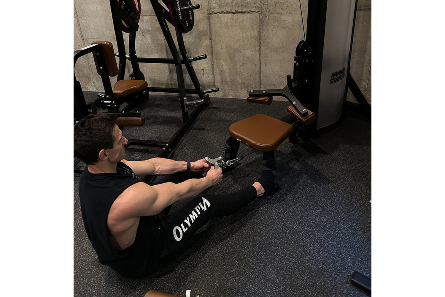Man using black and tan Hammer Strength dual pulldown row machine in gym setting