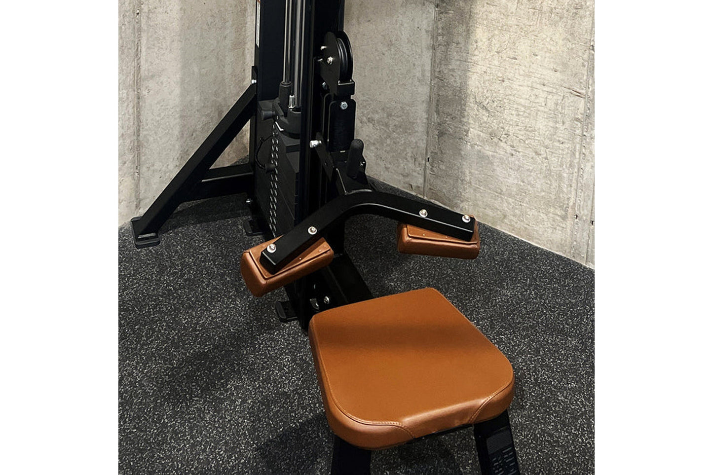 Black and tan leather gym machine with dual pulldown row attachments, pedal footrests, and triangular frame support on rubber
