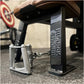Black and silver Hammer Strength dual pulldown row machine with metal handles, shown on gym floor with blurred equipment in b