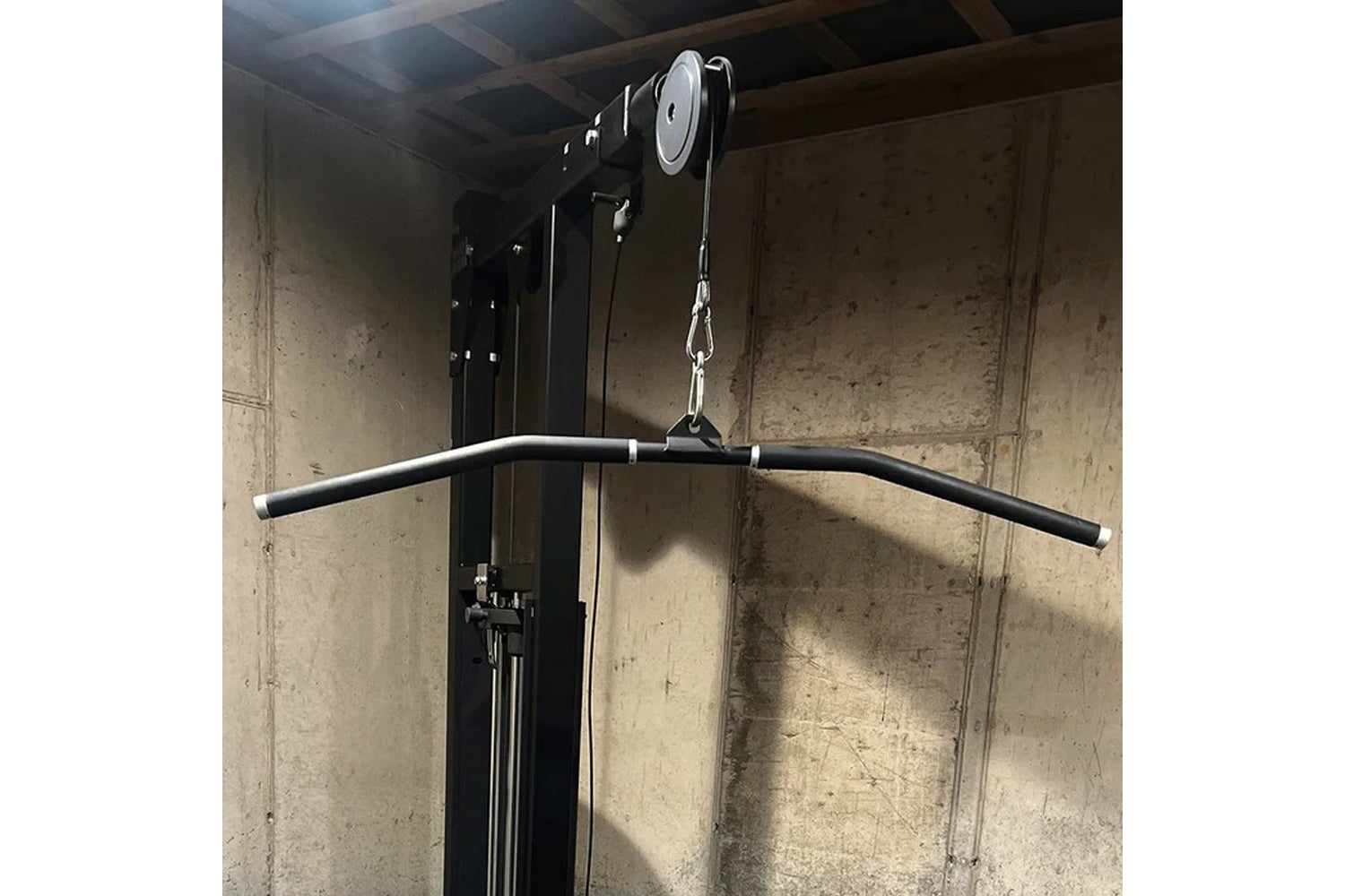 Hammer Strength HD Elite Dual Pulldown Row machine with black curved handles and silver pulley system mounted to concrete wal