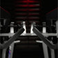 Black padded handles on Hammer Strength iso-lateral high row machine in gym setting with red accents
