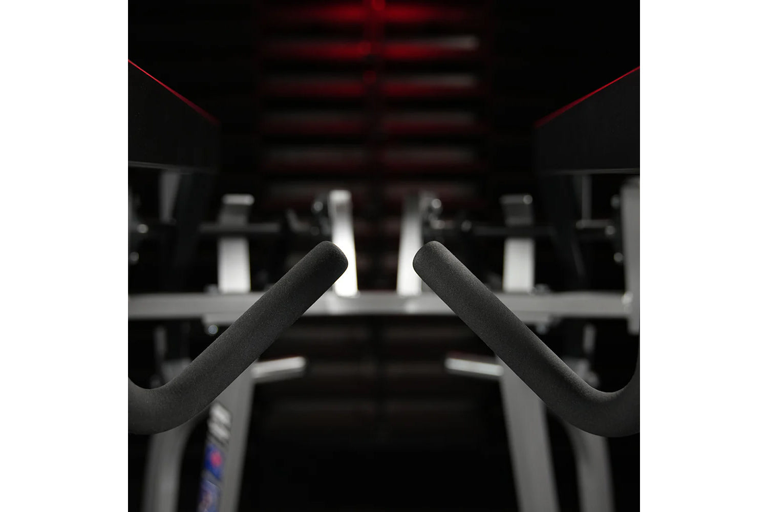 Black padded handles on Hammer Strength iso-lateral high row machine in gym setting with red accents