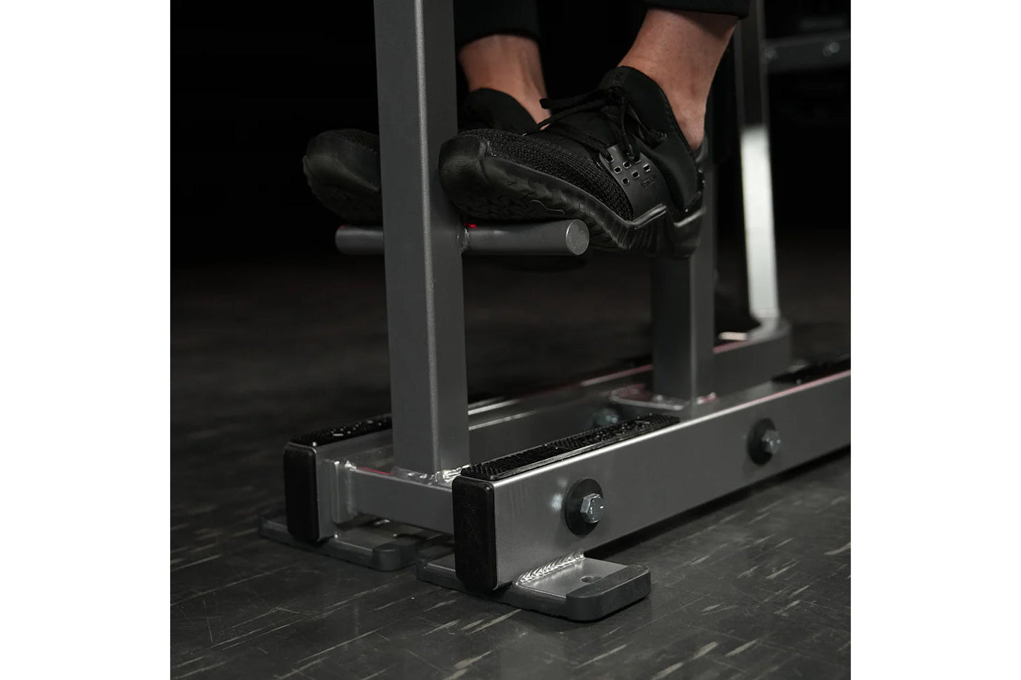 Person in black sneakers using Hammer Strength Iso-Lateral High Row machine in gym setting