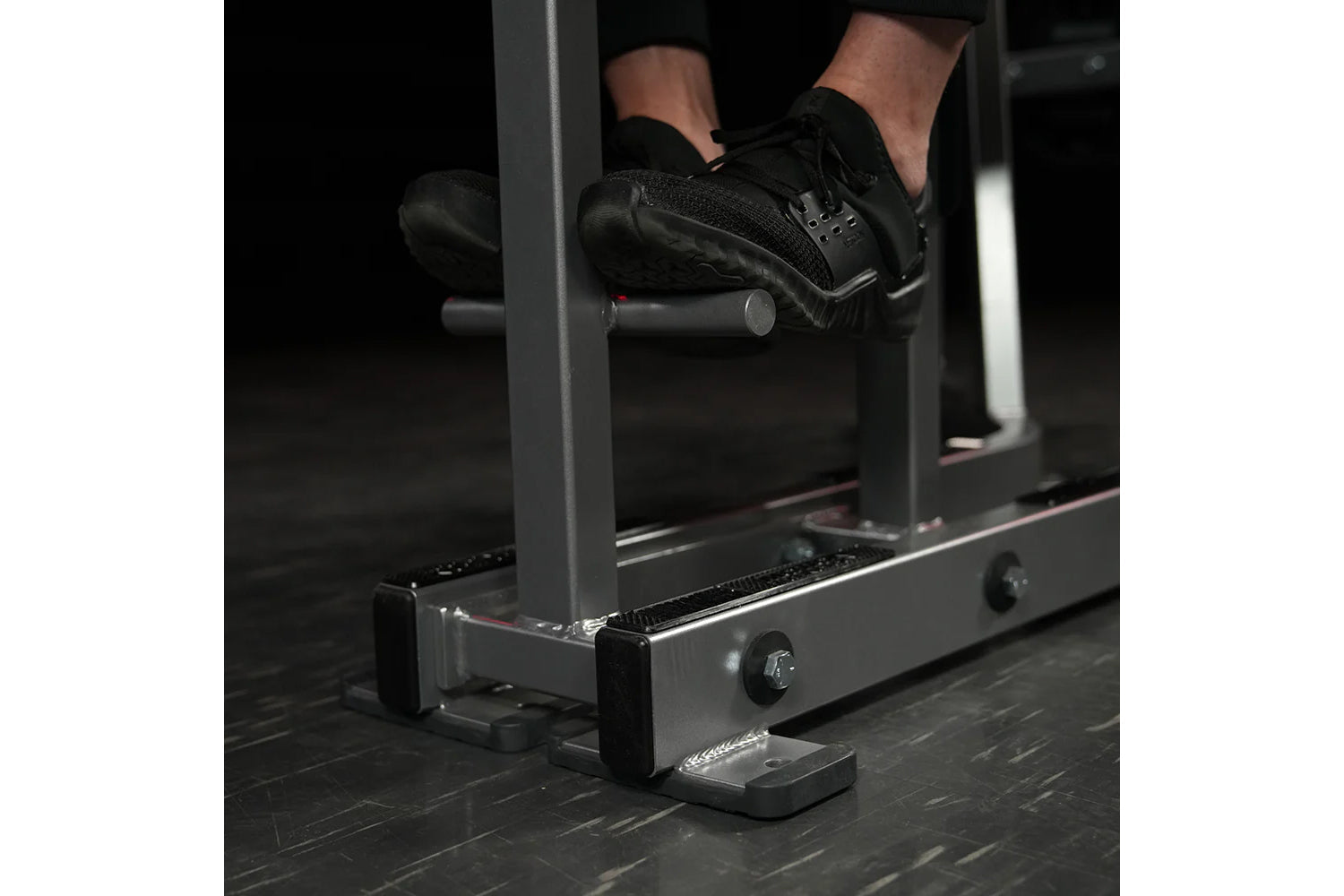 Person in black sneakers using Hammer Strength Iso-Lateral High Row machine in gym setting