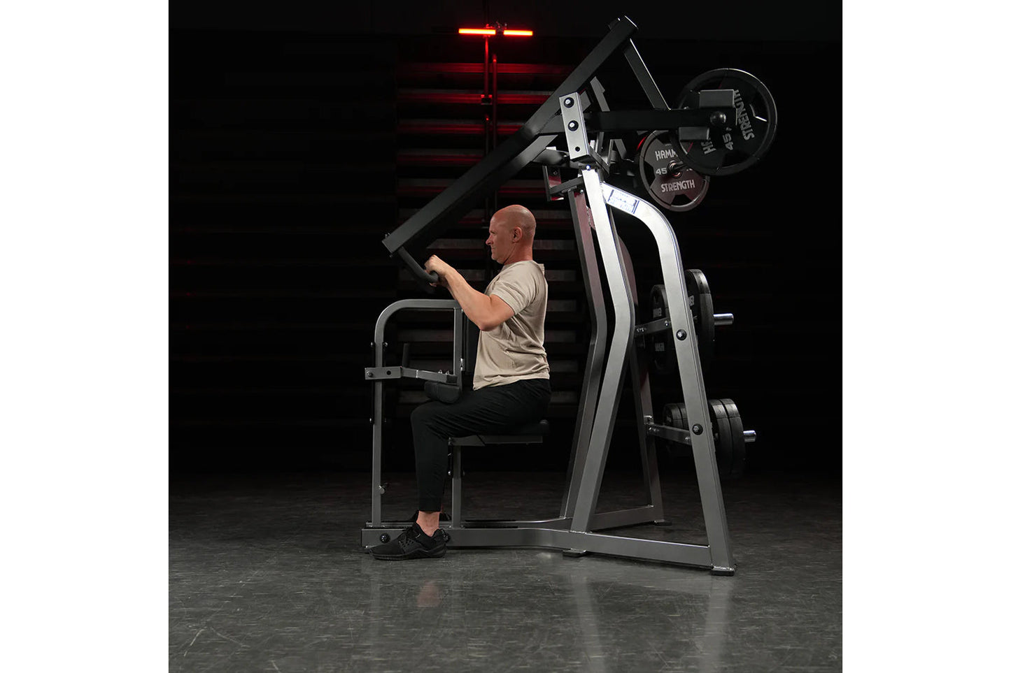 Hammer Strength Iso-Lateral High Row machine with gray and black frame, worn by male model in gym setting under red neon ligh