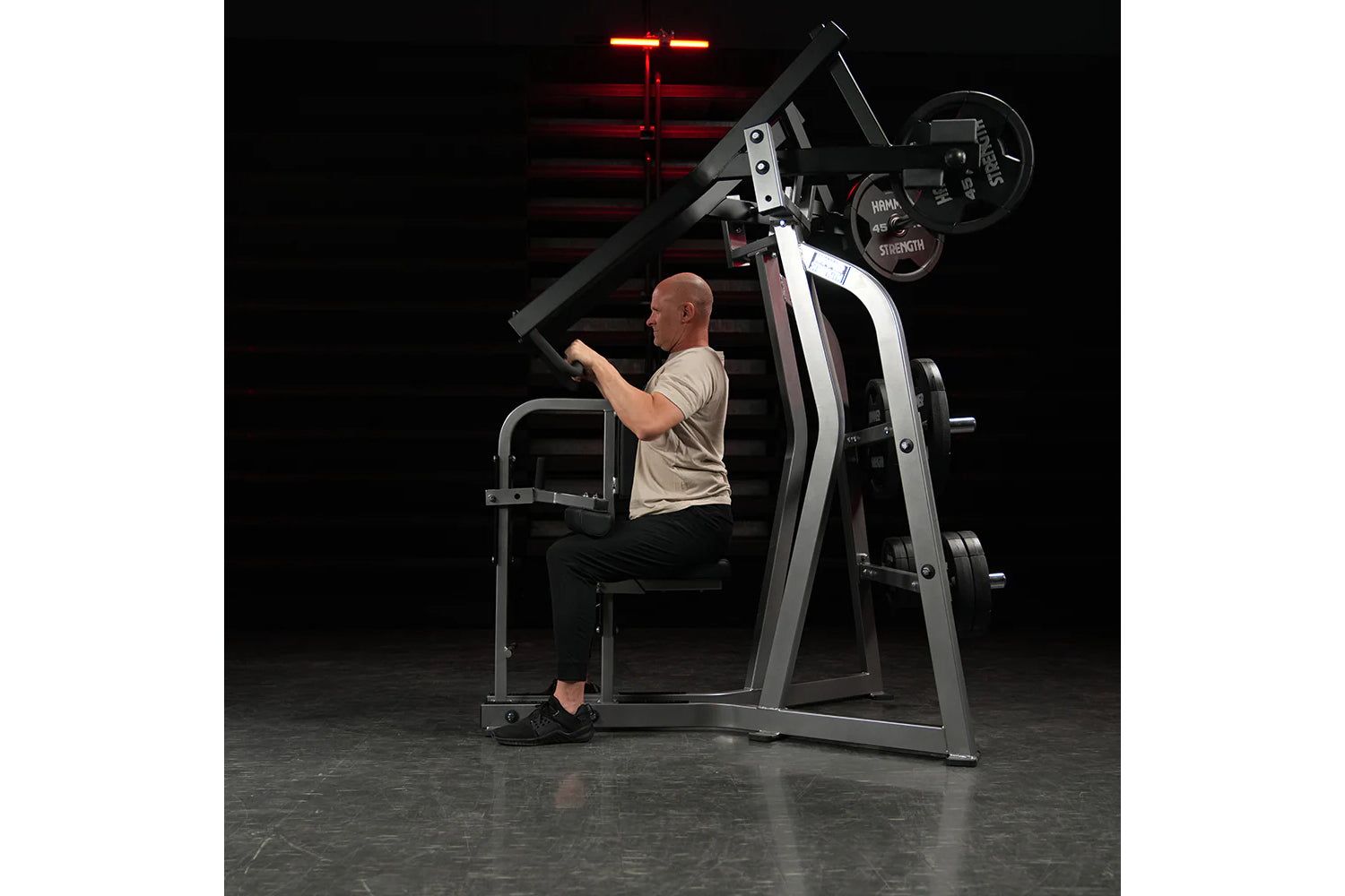 Hammer Strength Iso-Lateral High Row machine with gray and black frame, worn by male model in gym setting under red neon ligh