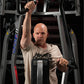 Man wearing beige Hammer Strength t-shirt using black Hammer Strength iso-lateral high row machine with arms extended overhea
