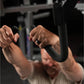 Person performing high row exercise with black handles on Hammer Strength machine in gym