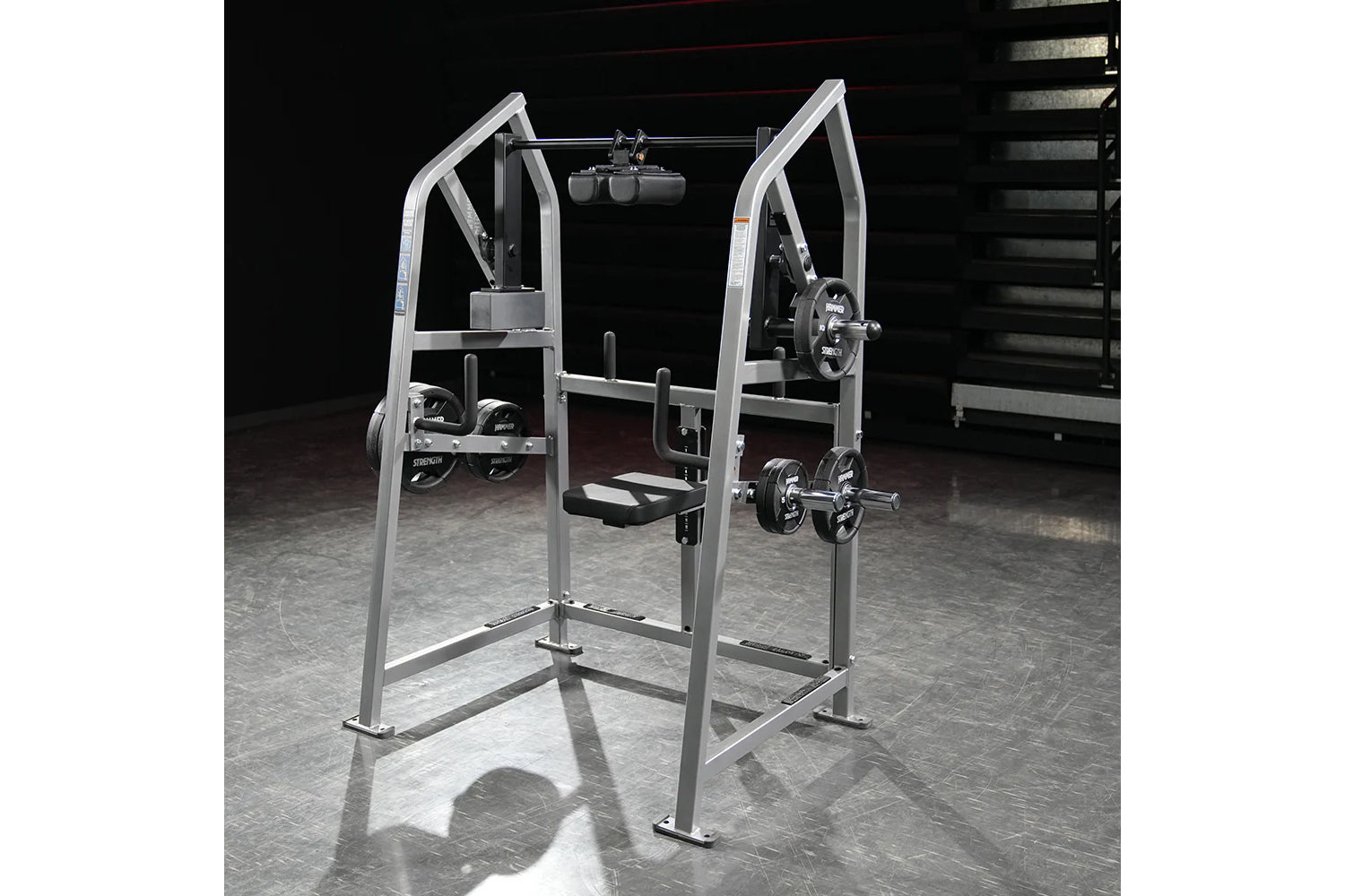 Hammer Strength plate-loaded 4-way neck machine with silver frame, weight plates, and footrest on gym floor