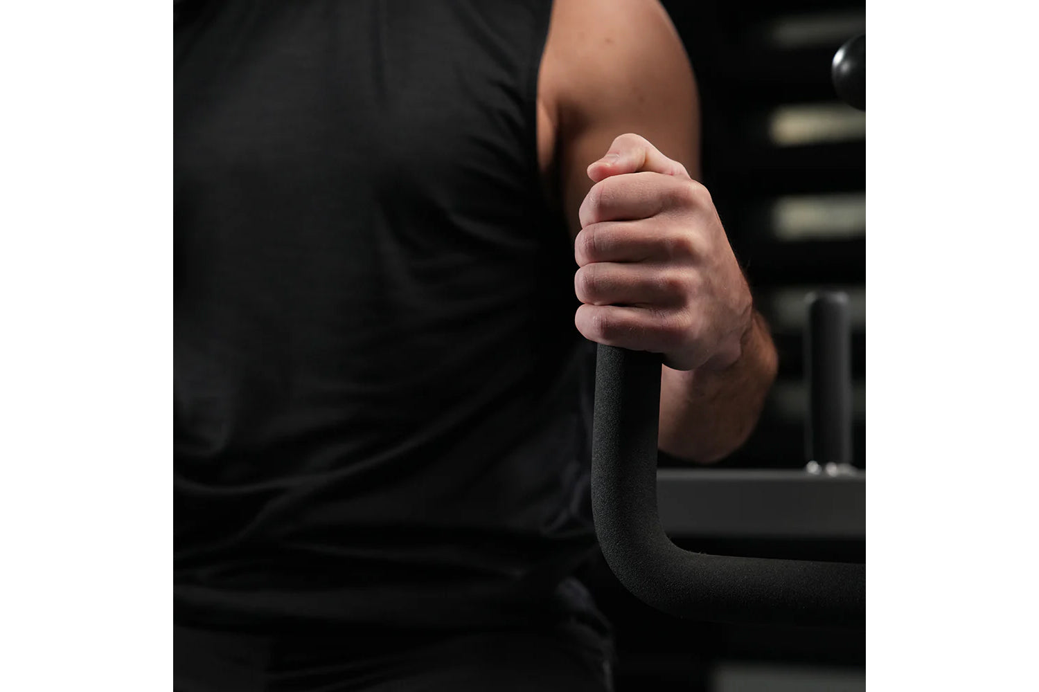 Person in black shirt gripping black foam-handled bar attachment on Hammer Strength neck exercise machine