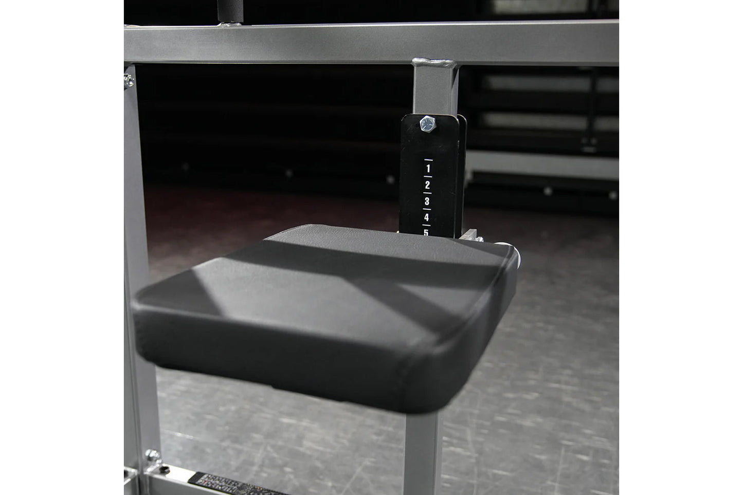 Hammer Strength plate-loaded 4-way neck machine with gray frame, black padded seat, and numbered adjustment dial on white bac
