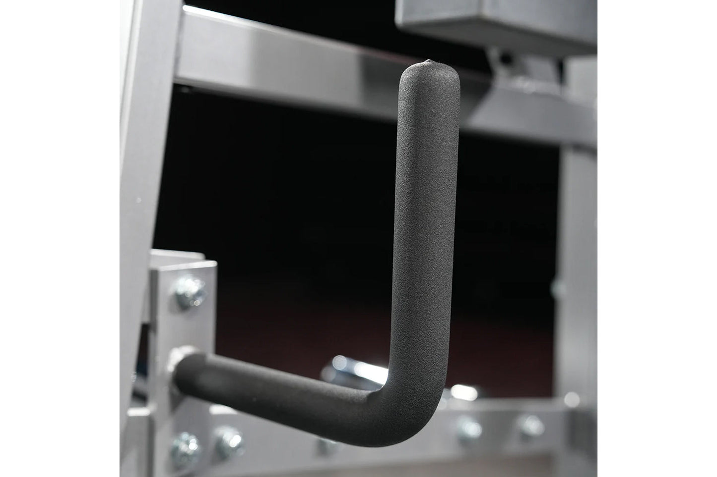 Black foam-padded neck exercise handle with J-shaped grip design mounted on plate-loaded machine