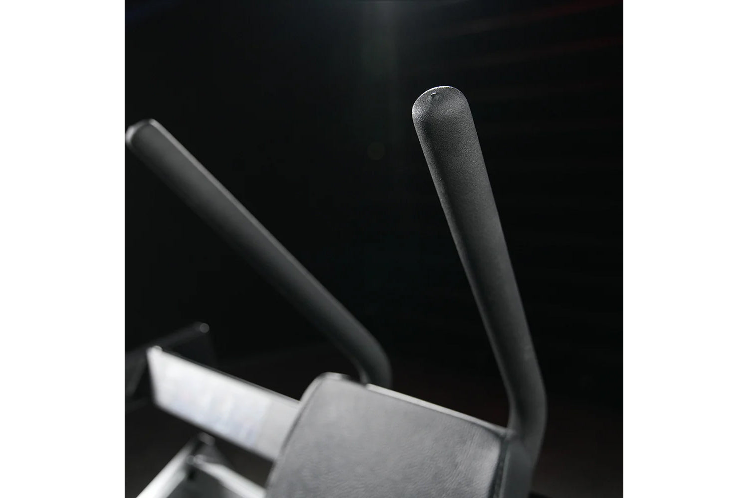 Hammer Strength plate-loaded abdominal oblique crunch machine with black handles and padded seat, on dark background