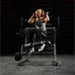 Woman in gray tank top and black leggings performing abdominal exercise on Hammer Strength plate-loaded machine in gym settin