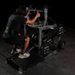 Person in black shirt performing squat exercise on Hammer Strength plate-loaded belt squat machine with weight plates loaded 