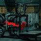 Black and red plate-loaded belt squat machine with chain attachment and foot platform in gym setting