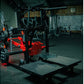Hammer Strength plate-loaded belt squat machine with red and black frame in gym facility setting