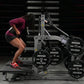 Athlete using Hammer Strength plate-loaded belt squat machine with 45-pound weight plates, wearing burgundy top and red sneak